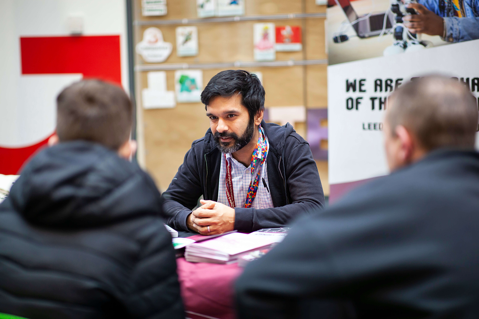 Leeds City College teachers speaking to a potential new student and their parent at one of the Colleges Open Events