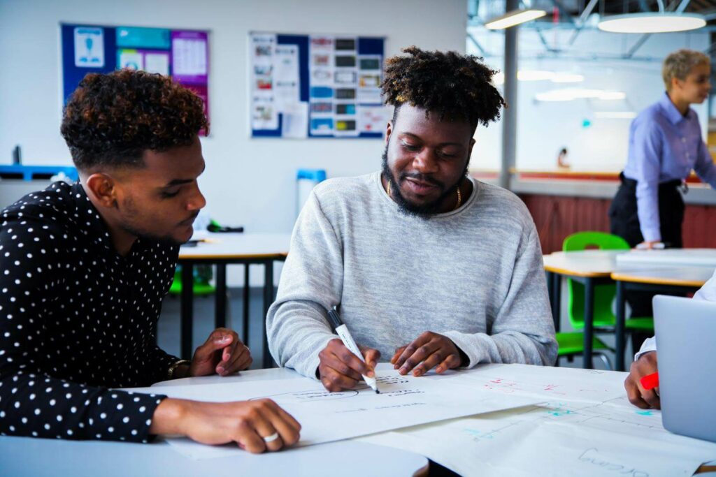 Two adult students working and writing down business plans and strategies
