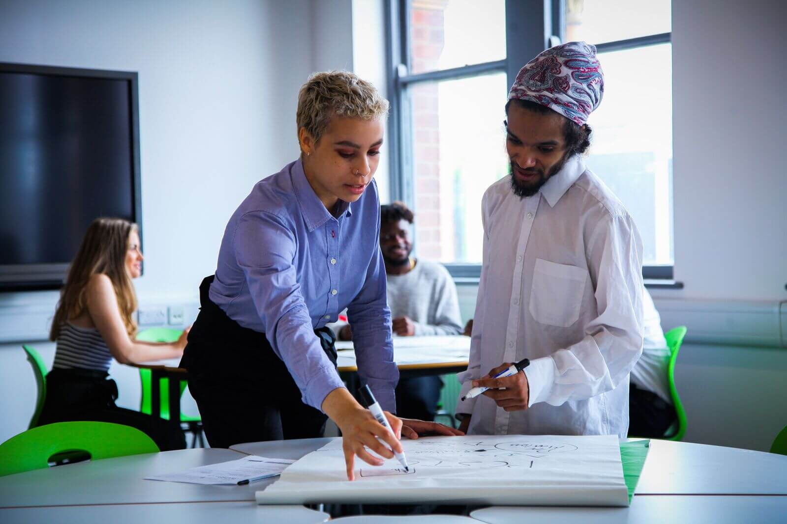 Class of business students, teacher helping the adult student