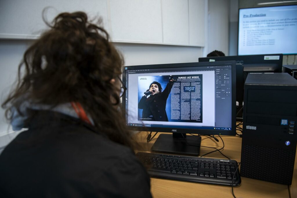 Creative Art student using a desktop working on design in the classroom
