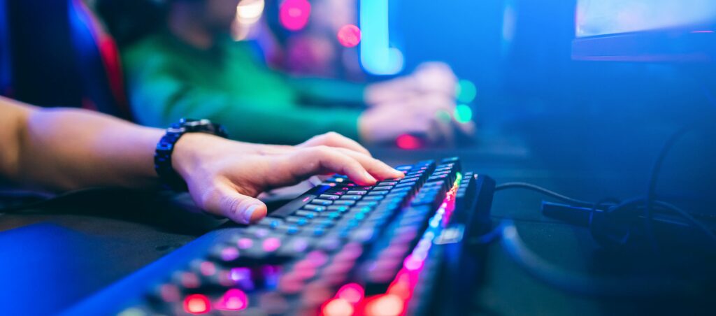 Photo of a keyboard and someone typing on it