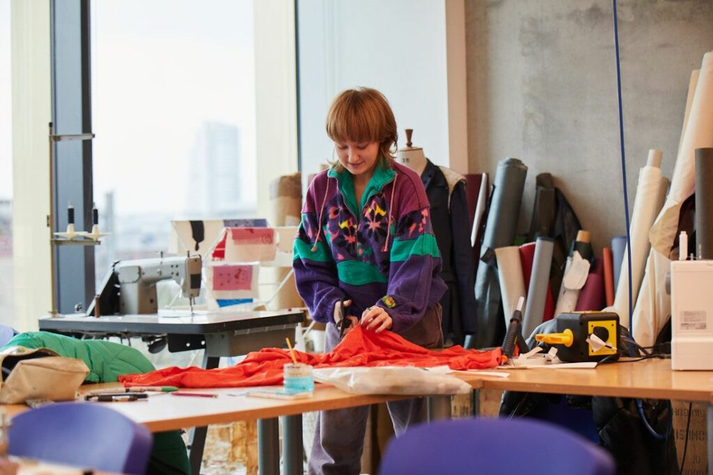 Creative arts student cutting fabric ready for dewing