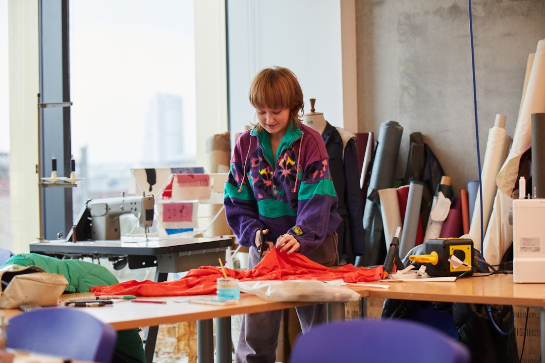 Creative arts student cutting fabric ready for dewing