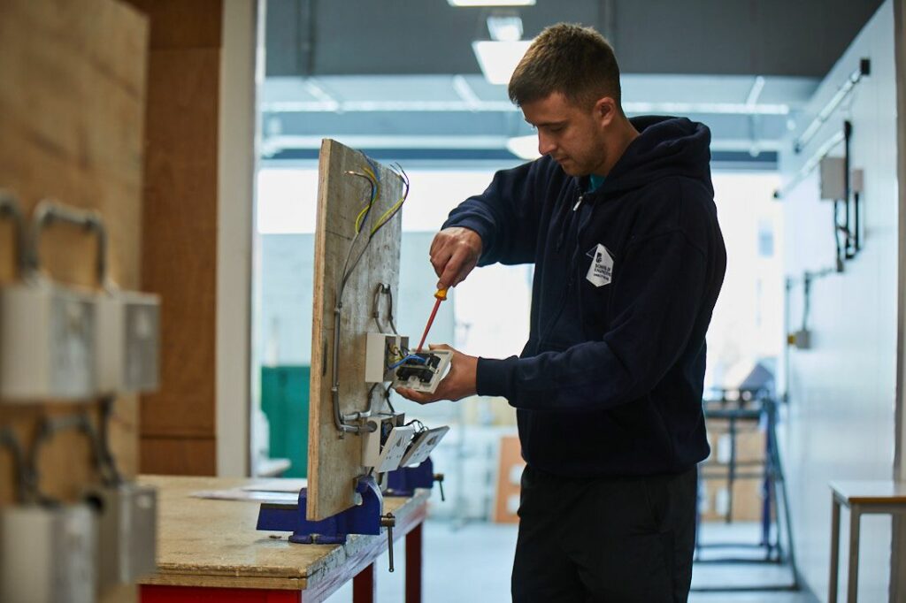 Engineering student working on wiring for a plug outlet