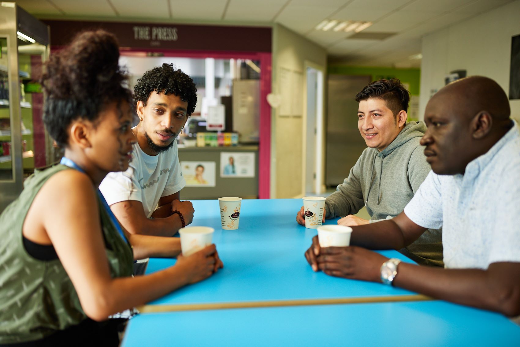 A group of adult learners drinking coffee and in discussion