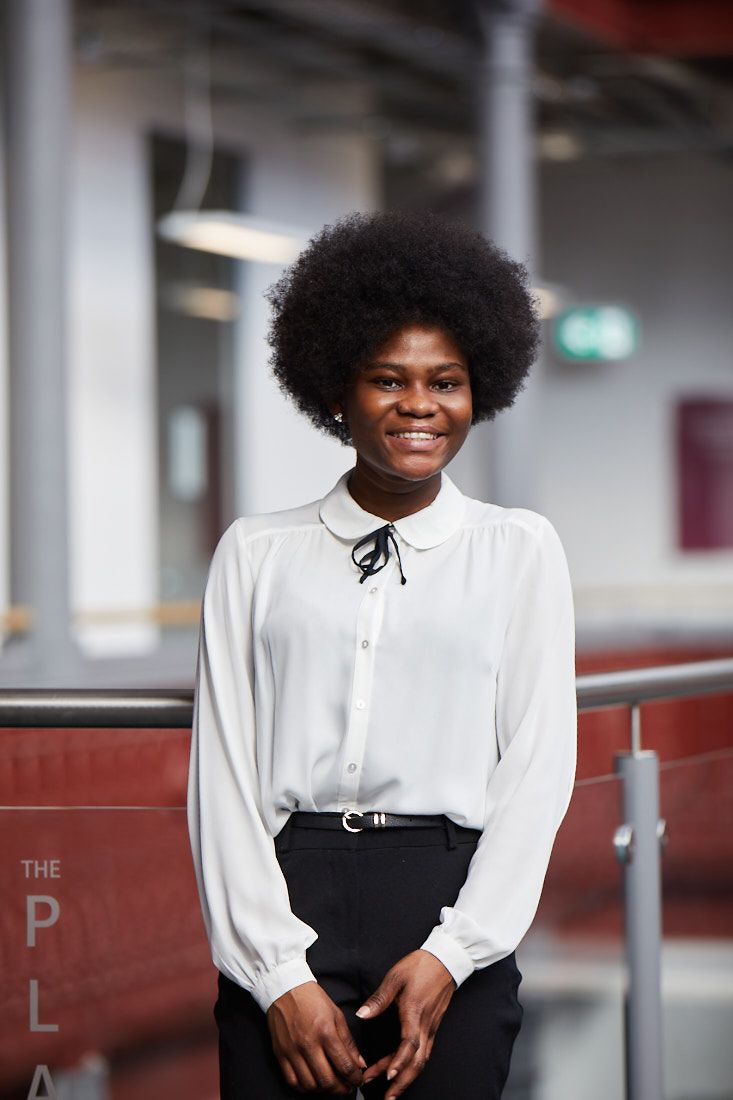 LCC Business student standing in the Printworks red print hall