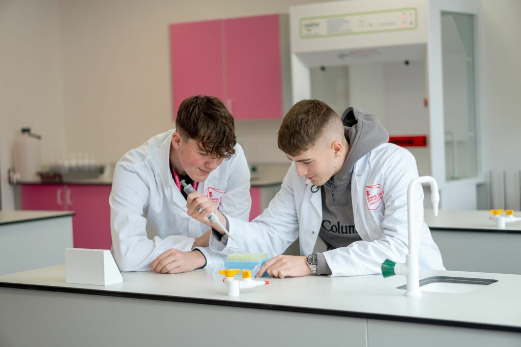 Two LCC Applied Science students working on an experiment putting chemicals in to test tubes
