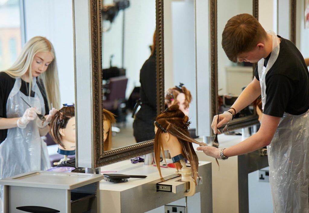 LCC Hair and beauty students applying highlights to hair on dummy heads