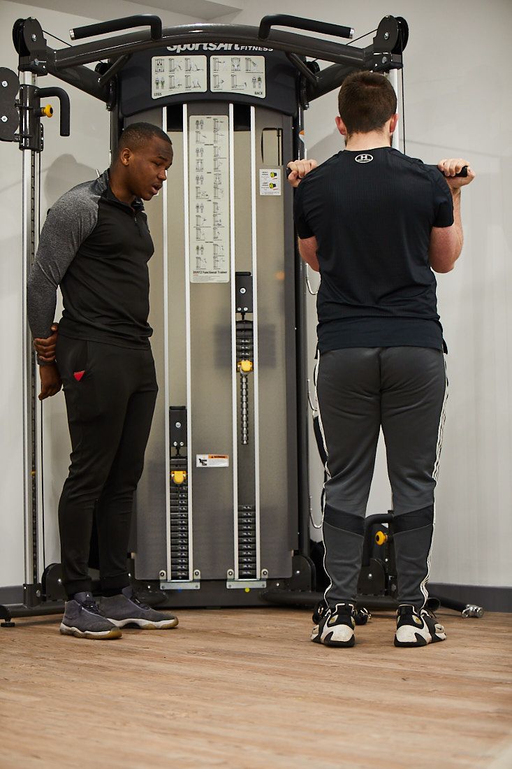 LCC sports student giving guidance on how to use gym equipment