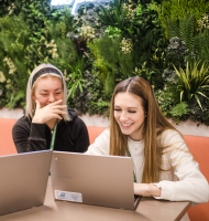 Two students working on a laptop