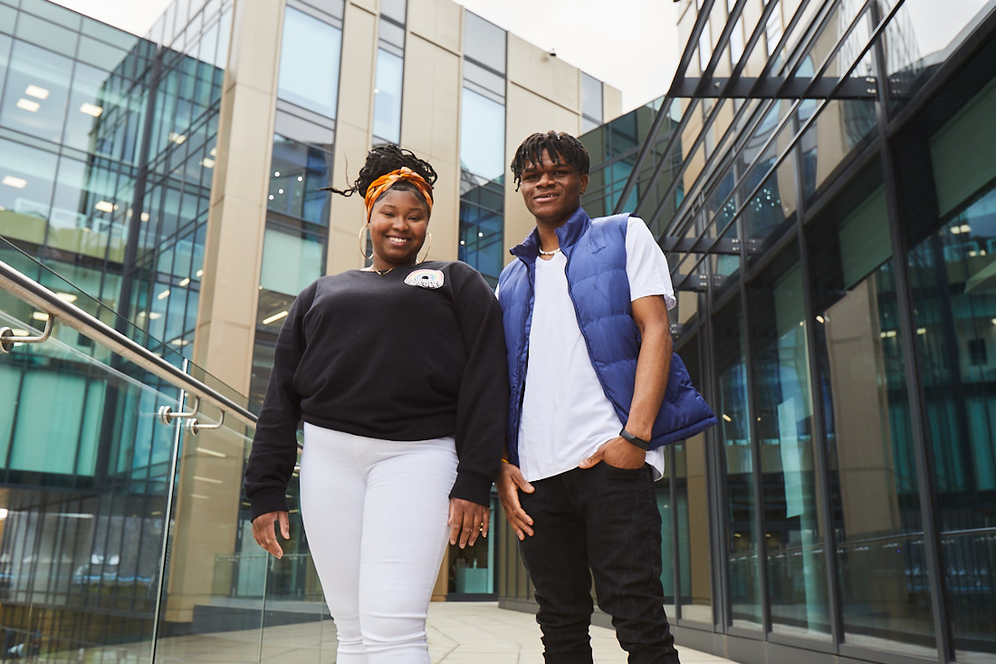 A male student and a female student standing next to each other smiling in front of Quarry Hill Campus