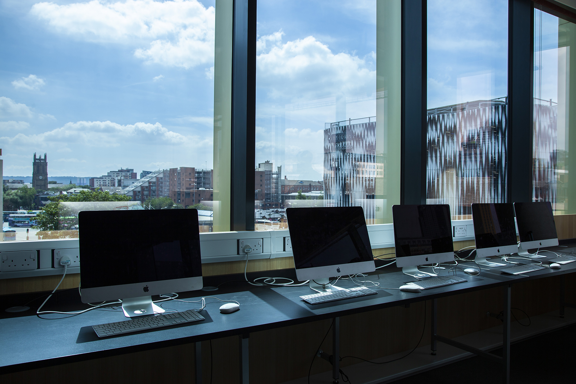 Classroom with iMacs displayed on table and glass window
