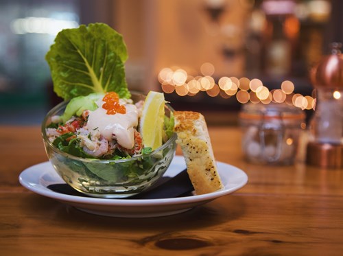 Salmon with egg on top served with lettuce