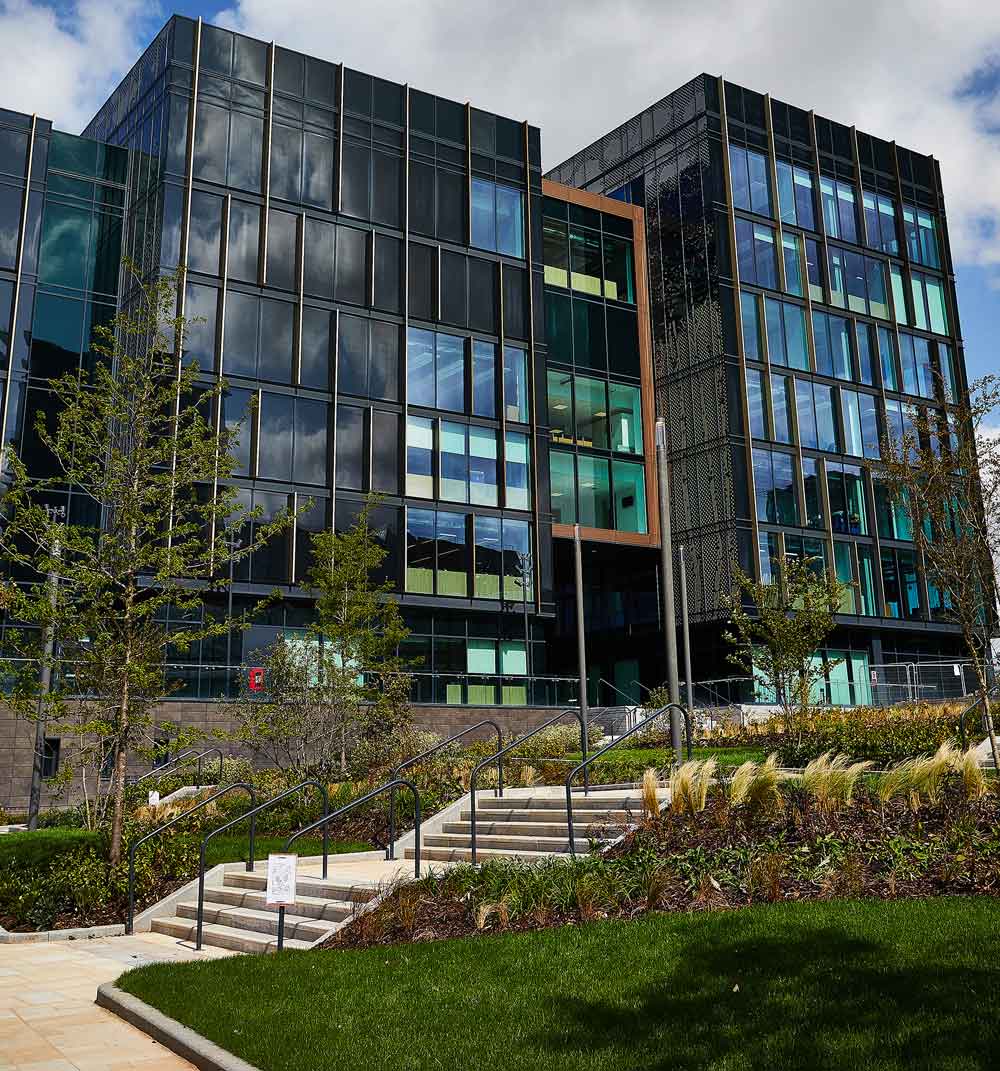 Quarry Hill buildings behind the front entrance steps surrounded by trees and grass