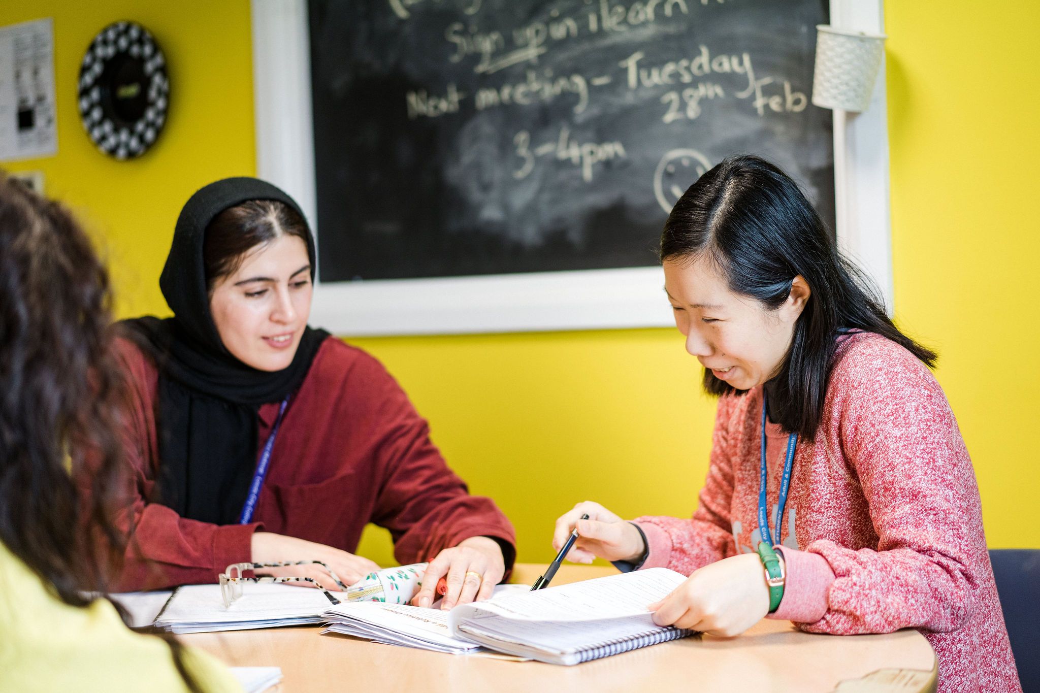 Deacon House adult English award, two adult students going through their notes written in their note pads