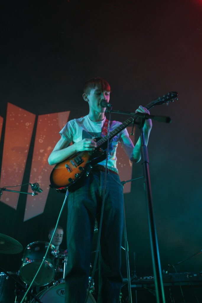Guitarist playing live whilst also singing on stage