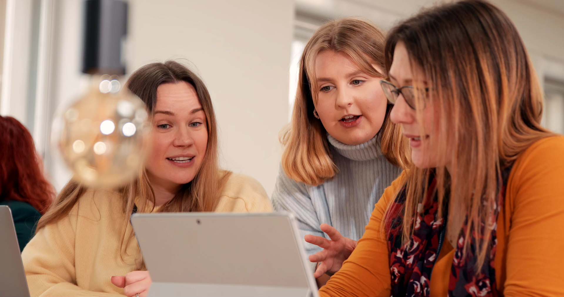 Students and lecturer sitting in the classroom with laptop having discussion