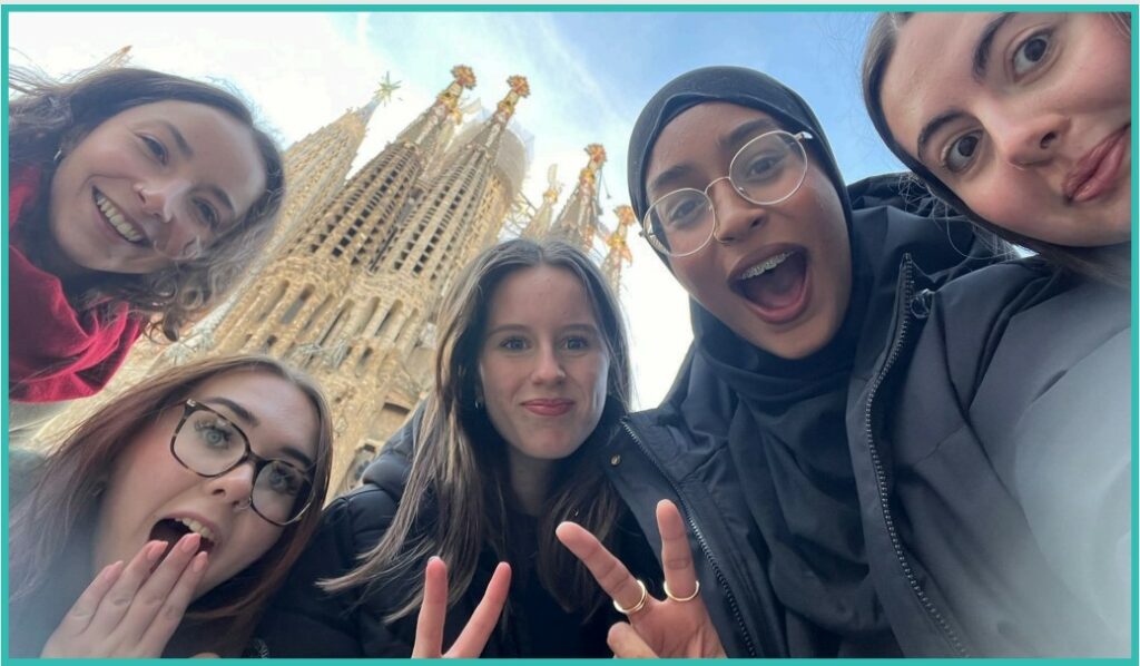Five Leeds City College students smiling at the camera outside the Sagrada Familia in Barcelona