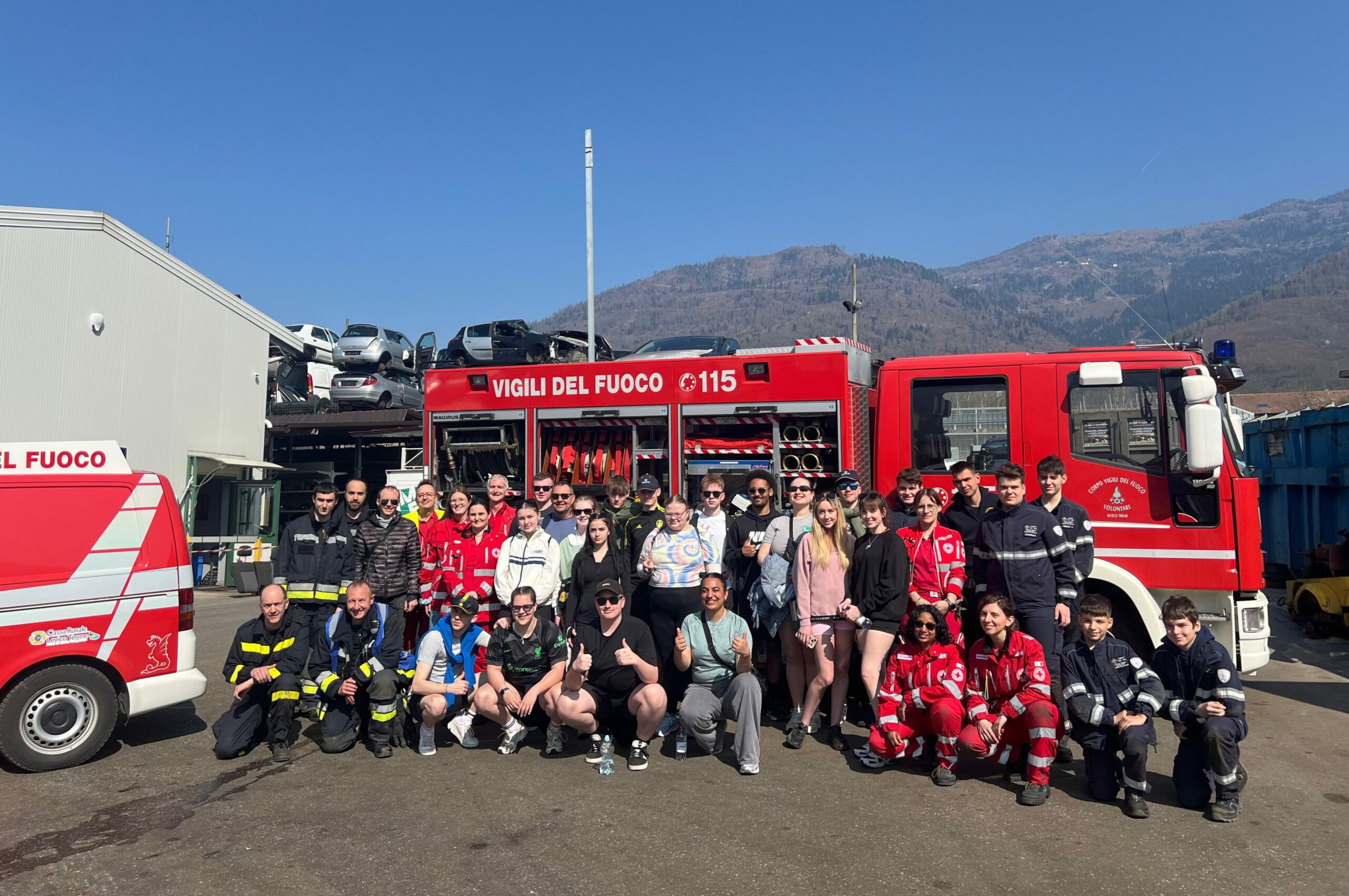 Group of students outside of a fire engine at a Vigili de Fuoco station in Italy.